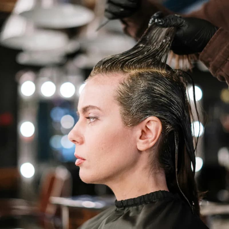 Stylist applying hair color to a client at Vibe Hair Studio